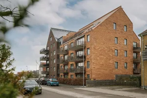 Modern residential apartments with wooden exterior on a cloudy day.