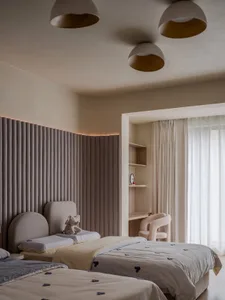 A modern gray bedroom featuring fabric bedding, wooden headboards, and glass and metal accents.