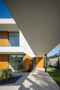 Modern house exterior with minimalist design features, large glass windows, and wooden accents.