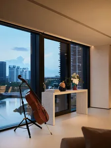 A modern living room featuring tile flooring, glass windows, and contemporary furniture.