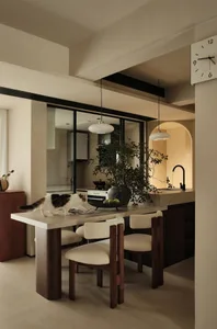Modern minimalist kitchen with concrete countertop and black and white cat.