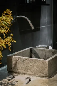 Concrete bathroom sink with minimalist design and industrial faucet.