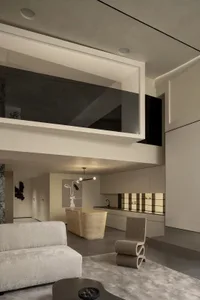 A cozy, minimalist residential interior with concrete finishes and modern furnishings, featuring an open-plan living area and