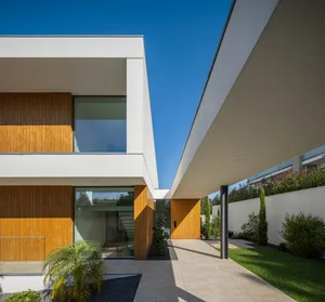 Modern residential building exterior featuring wooden accents, glass windows, and a concrete canopy.