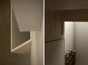 Minimalist white space with geometric shapes and light reflections on walls.
