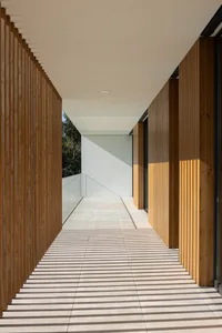 A modern interior hallway with wooden walls and a tiled floor, featuring a geometric shadow pattern.