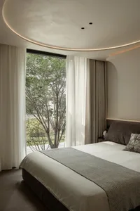 Minimalist bedroom featuring simple, elegant curtains.