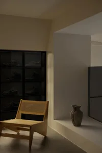 Contemporary minimalist room with a corner display of glass-encased sneakers.
