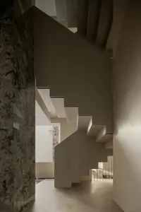 Concrete staircase with marble columns and white walls in a minimalist home interior design rendering.