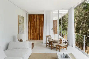 A minimalist white living space featuring wood elements and a spacious layout.