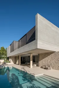 Modern residential architecture featuring a sleek, minimalist design with a concrete exterior and a swimming pool.