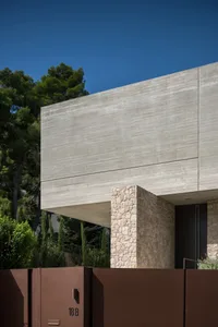 Modern residential building with concrete exterior and stone accents.