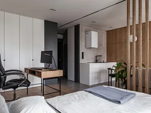 A minimalist living space featuring wooden furniture, metal accents, and concrete walls.