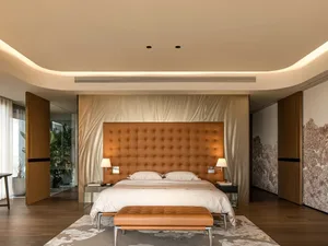 Modern bedroom featuring a leather headboard and marble floor.