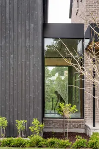 Modern residential exterior featuring dark wooden siding.