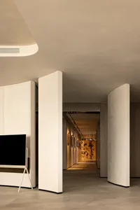 A modern entrance hall featuring curved concrete panels and minimalist design.