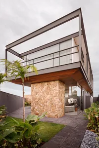A modern house exterior designed with stone and concrete materials.