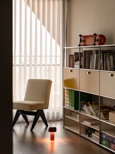 A modern children's playroom with a metal bookshelf displaying various books and a skateboard.