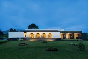A modern residential house featuring stone, glass, and cement materials.