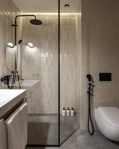 Modern, minimalist bathroom with engineered tile walls and a walk-in shower.