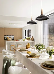 A minimalist, modern residential kitchen with a white marble countertop and wooden elements.
