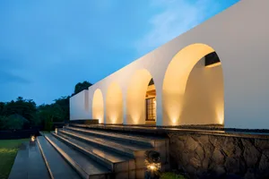 Modern architectural design featuring concrete archways lit from within.
