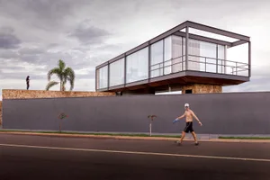 A modern house with a glass exterior on a cloudy day.