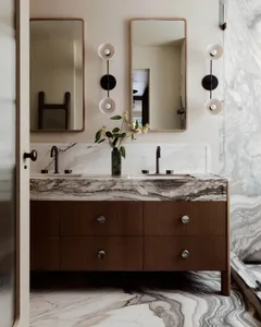 Modern bathroom with a marble vanity, two sinks, and sleek black faucets.