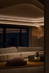 A minimalist residential interior with modern furniture and textured fabric on sofas and cushions.
