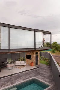 Modern residential architecture featuring glass walls, stone accents, and concrete floors.