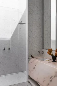 A modern minimalist bathroom featuring marble and concrete materials.