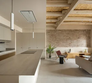 A modern kitchen with minimalist design features concrete countertops and walls.