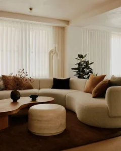 A comfortable and modern living room with a curved sofa, round coffee table, and minimalist decor.