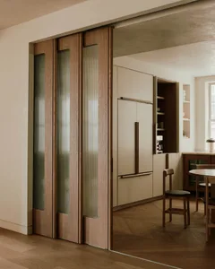 A modern minimalist kitchen with wooden and glass sliding doors.