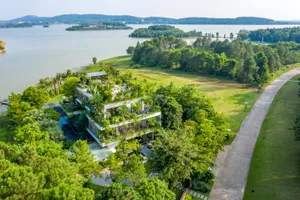 Modern residential building surrounded by lush greenery with a rooftop terrace