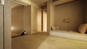 A minimalist residential living room featuring sandstone flooring and concrete walls.