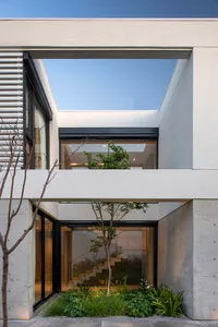 Modern architectural design featuring a glass wall and concrete structure.