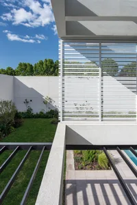 A modern concrete exterior with a lattice structure and greenery.