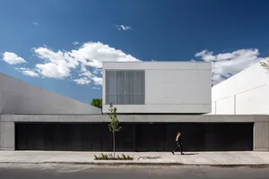 A contemporary office building with concrete walls and a glass facade.