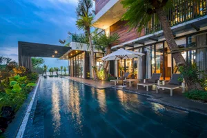 Modern residential exterior featuring concrete, palm trees, and a swimming pool.