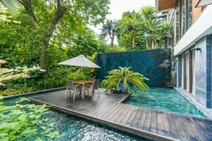 A modern residential pool area featuring wood and concrete materials.