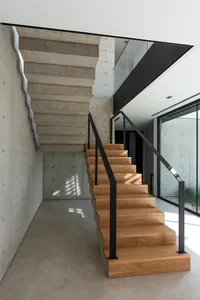 Modern staircase featuring concrete treads and wooden steps.