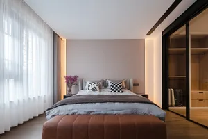 A modern bedroom with a monochromatic color scheme and minimalist decor.