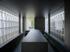 A sleek, modern business meeting room with polished concrete walls and a long, rectangular table.