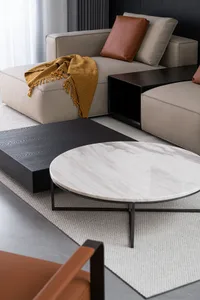Modern living room featuring a marble coffee table with an Eternal Black side table and a comfortable beige sectional couch w