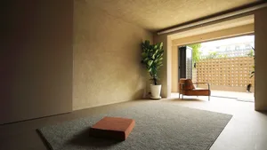A minimalist living room with a modern design, featuring a single orange armchair, a green plant in a white pot, and a gray c
