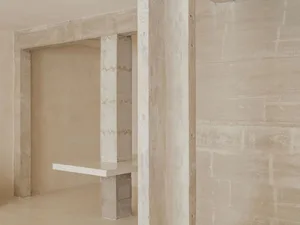 A serene minimalist interior design featuring concrete walls and flooring.