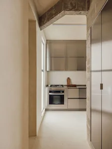 A minimalist kitchen with metallic cabinets, a stove, and a window.