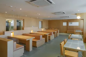 A modern cafeteria with wooden furniture and benches, featuring clean lines and a minimalist aesthetic.