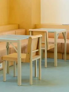 A modern furniture design featuring wooden chairs and tables with glass tops.